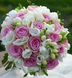 a bouquet of pink and white flowers sitting on top of a table