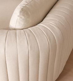 the back end of a couch with pleated fabric