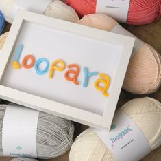 yarn balls and crochet are arranged around a framed sign that reads'lorapa '