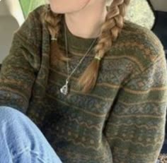 a woman sitting in the back seat of a car with her hair pulled up into a braid