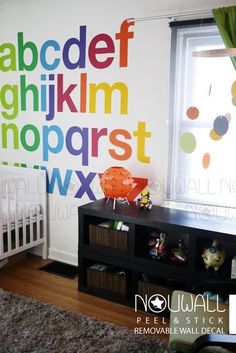 a child's room with colorful wall decals and a crib in the corner