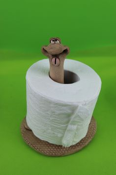 a close up of a roll of toilet paper with a frog on it's head