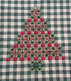 a green and white checkered table cloth with a red christmas tree on the front