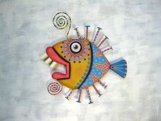 a colorfully painted fish sitting on top of a white surface