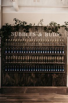 there is a sign that says bubbles and buds on the wall next to beer bottles