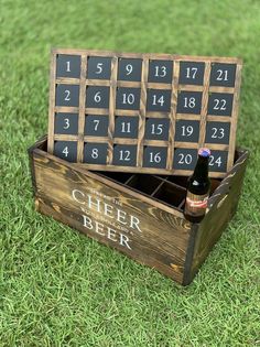 a beer bottle in a wooden box with numbers on it and a calendar sitting inside