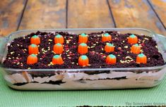 a cake in a pan with chocolate frosting and mini pumpkins on the top