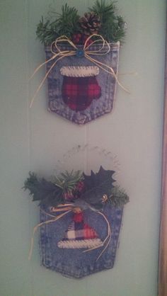 two christmas baskets hanging on the wall with holly and pine cones tied to them in twine