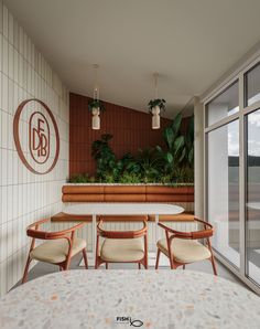 a table and chairs in front of a window with plants on the wall behind it