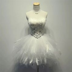 a mannequin dressed in white with feathers on it