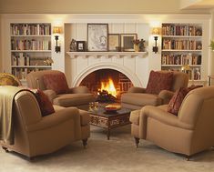 a living room filled with furniture and a fire place in the middle of the room