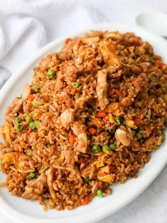 a white plate topped with fried rice and vegetables