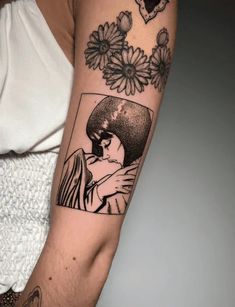 a woman's arm with flowers and a photo on the back of her shoulder