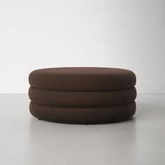 a brown ottoman sitting on top of a white floor