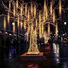 a lighted tree in the middle of a city street