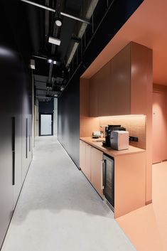 an empty room with pink walls and black ceilinging is seen in this image, there are appliances on the counter