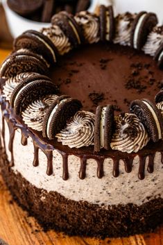 an oreo cookie cake with chocolate icing on a wooden table next to cookies