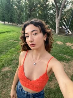 a woman in an orange crop top posing for the camera