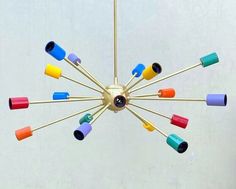 a multicolored chandelier hanging from the ceiling with eight lights on it