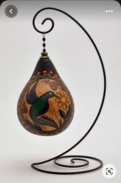 an artistically painted egg hanging from a metal stand