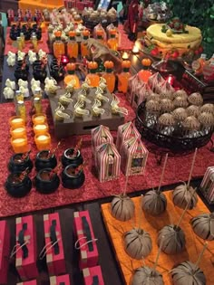 an assortment of desserts and candies displayed on a buffet table at a halloween party