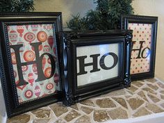 three framed pictures sitting on top of a table next to a christmas tree in front of them