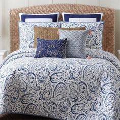 a blue and white comforter set with pillows