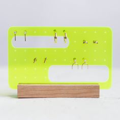 a pair of earring hooks are attached to a green board with pegs on it