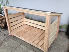 a dog house made out of pallets and wooden slats is sitting on the ground