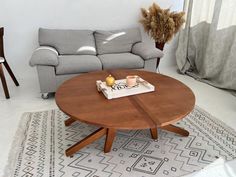 a living room with a couch, coffee table and rug on the floor in front of it