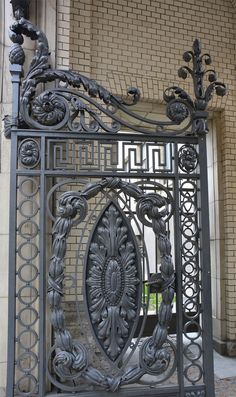 an ornate iron gate in front of a brick building