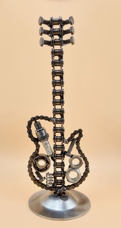 a clock made out of metal parts on a stand