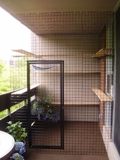 a caged balcony with flowers and plants in it