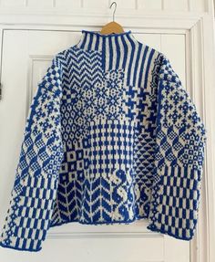 a blue and white sweater hanging on a door