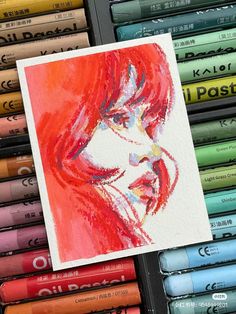 a painting of a woman's face surrounded by colored crayon pencils