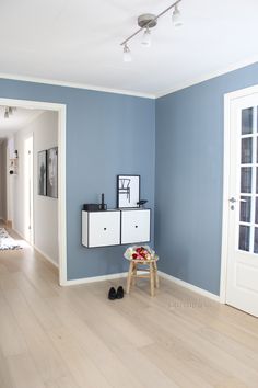 a living room with blue walls and white furniture