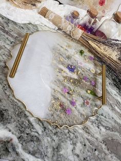 a marble table topped with a mirror and gold trimmings next to other items