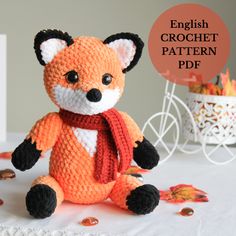 an orange knitted fox sitting on top of a table