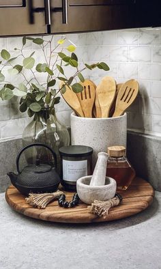 wooden utensils and spoons are on a cutting board in the kitchen counter