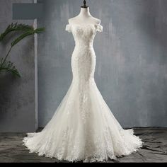 a white wedding dress on display in front of a gray background with the words mrs win