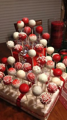 a table topped with lots of red and white cake pops