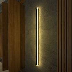 a wall light that is on the side of a wall next to some wood doors