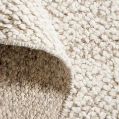 a close up view of the corner of a rug with white and beige textured material