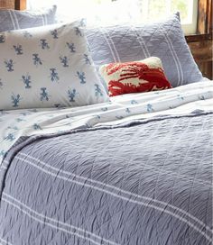 a bed with blue and white bedspread and pillows