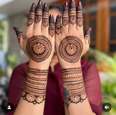 a woman holding her hands up with hendi designs on it