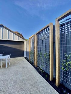 a fenced in backyard area with a table and chairs