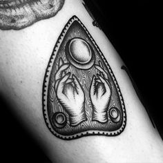 a black and white tattoo with two hands holding an object in the shape of a triangle