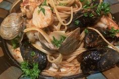 a plate of pasta with clams and shrimp