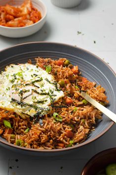 a bowl filled with rice and vegetables on top of a table