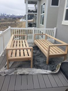 two wooden benches sitting on top of a porch